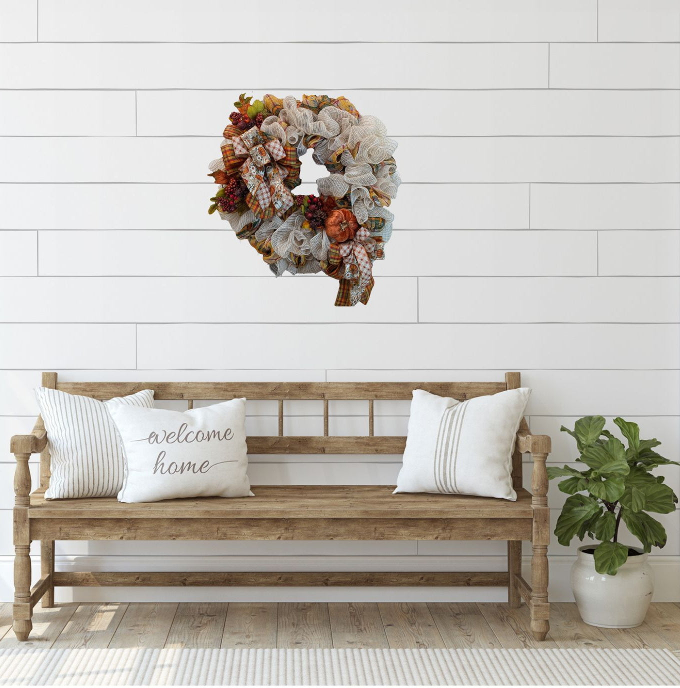 Fall Wreath with beige deco mesh base with a curly Q design. There are 2 matching bows with orange, gold, green and beige patterned ribbons. It has a velveteen pumpkin, acorns, pinecones and fall foliage.